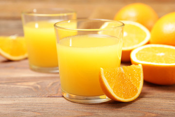 Naklejka na ściany i meble Orange juice in a glass, oranges and orange slices on the table.