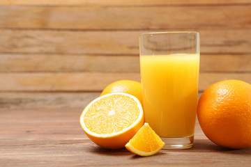 Orange juice in a glass, oranges and orange slices on the table.