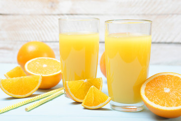 Orange juice in a glass, oranges and orange slices on the table.