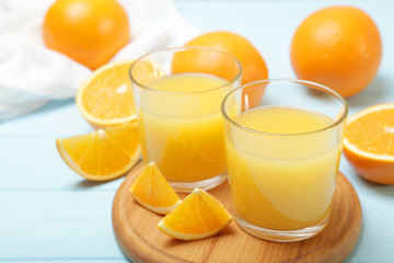 Naklejka na ściany i meble Orange juice in a glass, oranges and orange slices on the table.