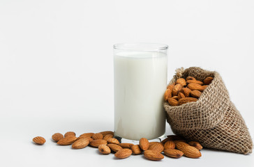 Milk with almonds nut on white background.