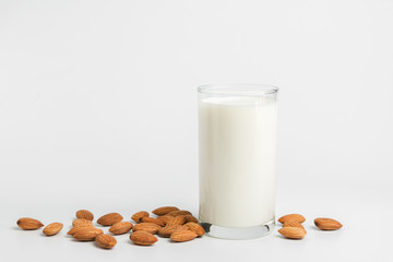 Milk with almonds nut on white background.