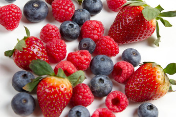 Mixed berries blueberry raspberry strawberry closeup on white background