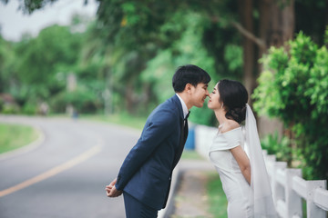 Wedding photo outdoor,  Young couples are happily kissing each other on the wedding day.