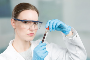 woman with medical gloves is holding a blood probe