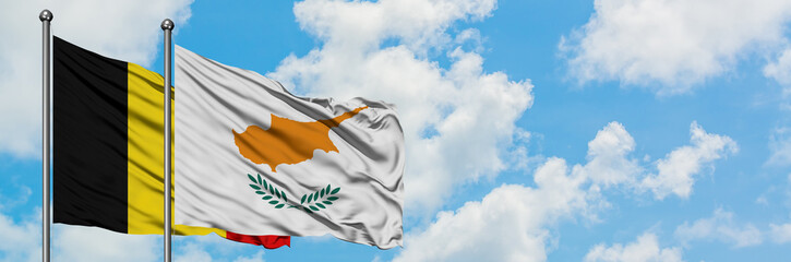 Belgium and Cyprus flag waving in the wind against white cloudy blue sky together. Diplomacy concept, international relations.
