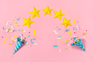 Colorful paper confetti exploding and five star on pastel pink background