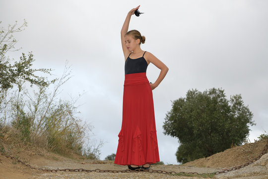 Girl in a flamenco position on a country road