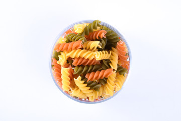  Glass jar filled with dry rotini yellow pasta over isolated white background 