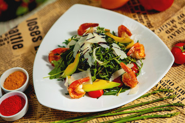 close up of fried shrimp salad with avocado, arugula, parmesan and cherry tomato