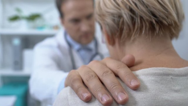 Male doctor comforting crying female patient, bad diagnosis, terminal illness