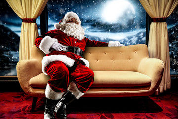Red old Santa Claus on sofa and free space for your decoration. 