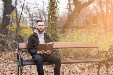 Hipster man reading on a bench