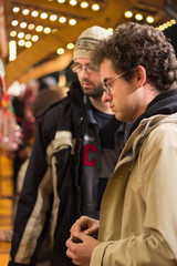 Fototapeta premium Young boys at a Christmas market buying. Christmas concept.