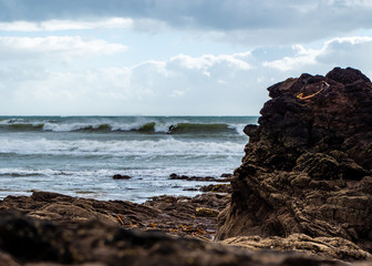 Surfer riding a wave, viewed from the rocks