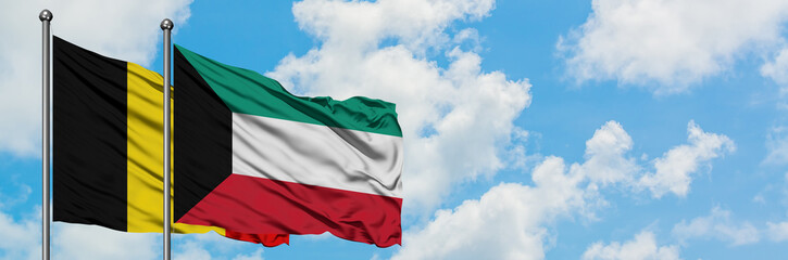 Belgium and Kuwait flag waving in the wind against white cloudy blue sky together. Diplomacy concept, international relations.
