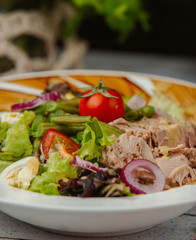 close up of tuna salad with onion, tomato, lettuce, and eggs