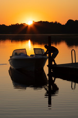 Fishermen departing in a small powerboat at dawn for a day of adventure in a Florida lake.