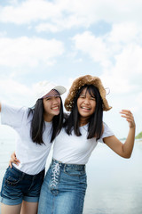 two cheerful asian teenager happiness on vacation sea beach