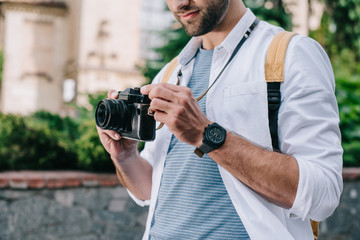 cropped view of bearded man holding digital camera