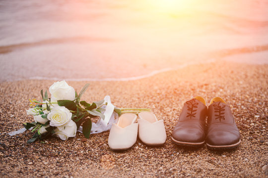 Close-up photos of a bouquet of flowers and shoes, the groom and the bride, placed on the sandy beach.