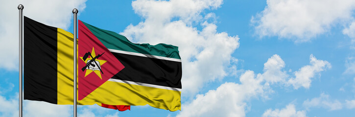 Belgium and Mozambique flag waving in the wind against white cloudy blue sky together. Diplomacy concept, international relations.