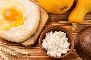 Home kitchen. Billet for baking on a wooden background. Near yellow pumpkins and ears of wheat