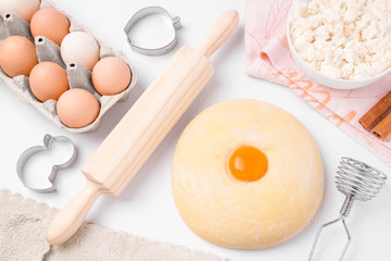 Ingredients for baking. Eggs, cottage cheese, dough on a light background. Homemade food
