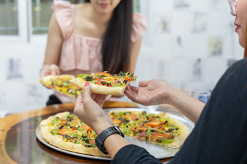 Close up of happy friends eating pizza together.