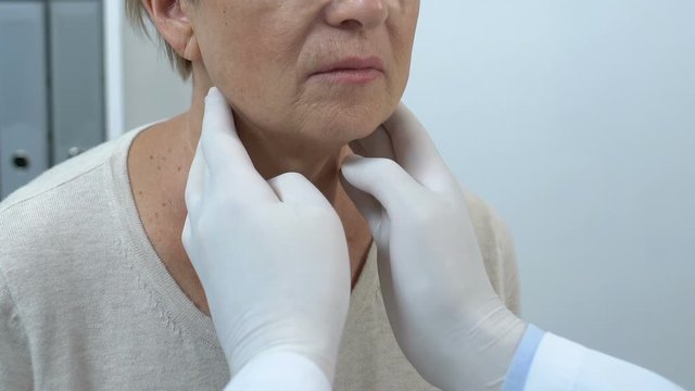 Oncologist checking elderly female lymph glands, risk of throat cancer, health
