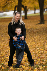 Cute young mother and son posing for portrait in autumn color