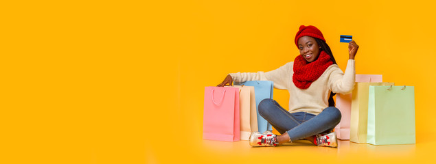 Girl in red hat sitting on floor with shopping bags
