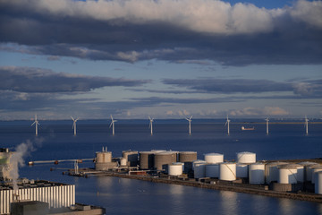 View of the plant from the outside, pipes smoke, wind turbines in the sea, barrels, tanks, thermal...