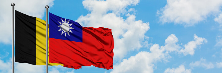 Naklejka premium Belgium and Taiwan flag waving in the wind against white cloudy blue sky together. Diplomacy concept, international relations.