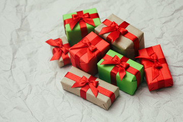 Set of gift boxes wrapped in craft paper and tie red satin ribbon. Christmas presents. Holiday mood. New year decor.