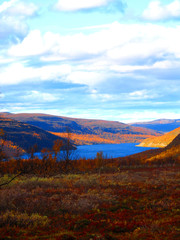 Mountain landscape in Northern Norway. Autumn colors, mountain lake, turquoise cloudy sky. Awesome fall season.
