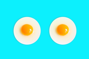 Two Organic round  (White eggs and  yolk )of chicken Cooked high protein good for health decorative isolated on pastel light blue food background texture close-up