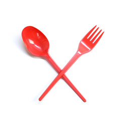 Plastic red disposable spoon and fork crossed. Close up. Isolated on white background