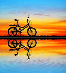 Obraz premium silhouette vintage bike on sunrise