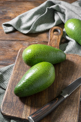 Avocado and knife on a wooden Board on a wooden table