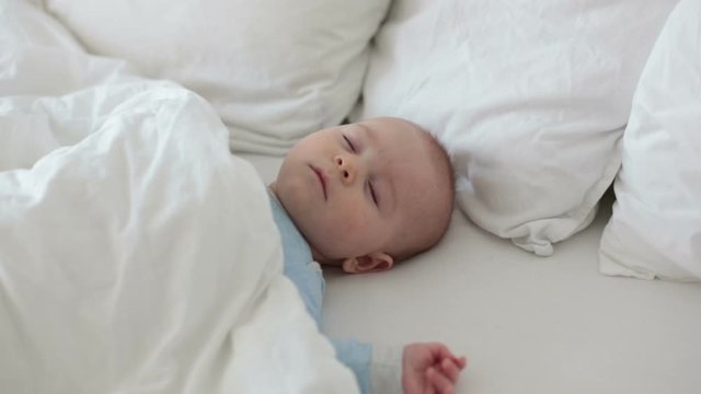 Close up of a little baby boy sleeping, baby lying in baby cot