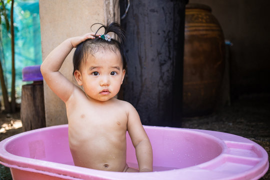 Little kid enjoying to take a bath in bath tub outdoor