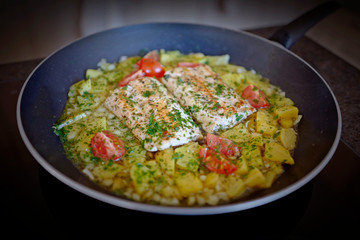 salmon fillet with potatoes and tomatoes in olive oil