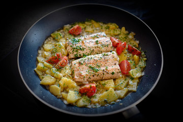 salmon fillet with potatoes and tomatoes in olive oil