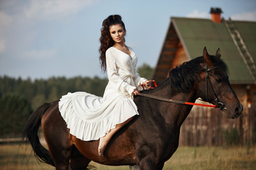 Girl in a long dress riding a horse, a beautiful woman riding a horse in a field in autumn. Country life and fashion, noble steed - Powered by Adobe