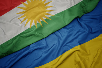 waving colorful flag of ukraine and national flag of kurdistan.