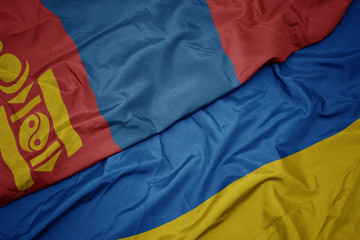 waving colorful flag of ukraine and national flag of mongolia.