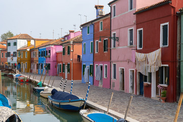 Naklejka na ściany i meble Colorful houses in Burano island. Canal view with boats. Travel photo. Venice. Italy. Europe.