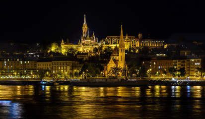 Fototapeta na wymiar View of the evening Budapest from a pleasure boat. Buda in the evening illumination. Night city. Danube river at night. Walk and tour the Danube.
