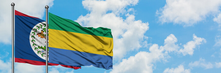 Belize and Gabon flag waving in the wind against white cloudy blue sky together. Diplomacy concept, international relations.